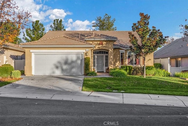 mediterranean / spanish-style house with a front yard and a garage