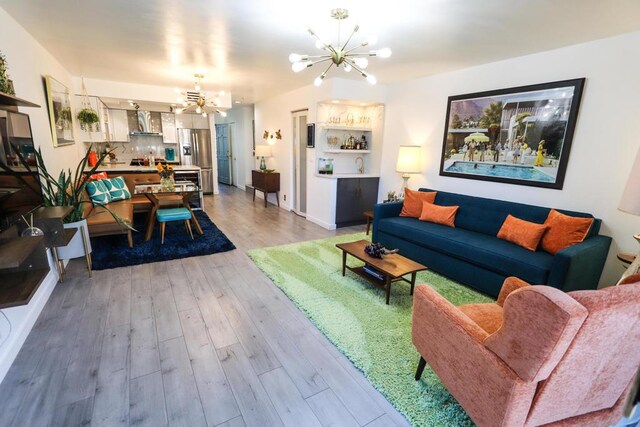 living room with light hardwood / wood-style floors and an inviting chandelier