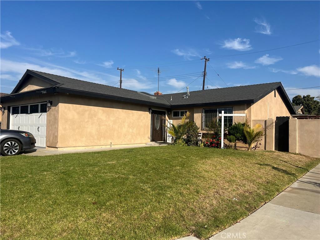 ranch-style house featuring a garage and a front lawn