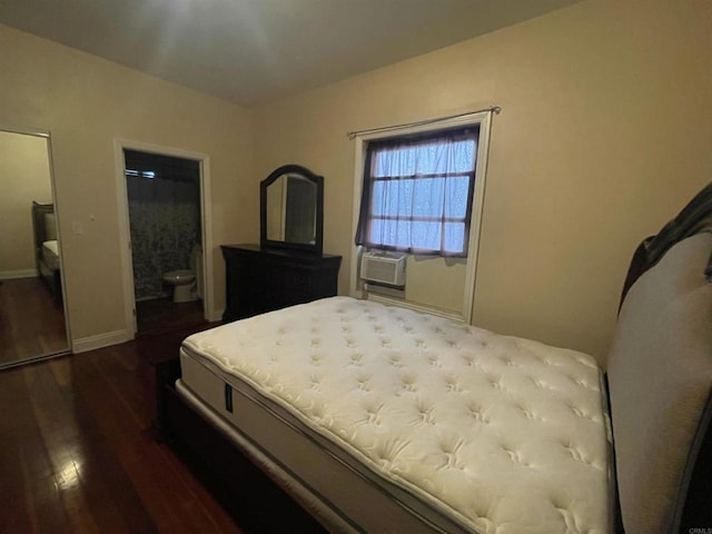 bedroom with connected bathroom, cooling unit, and dark wood-type flooring