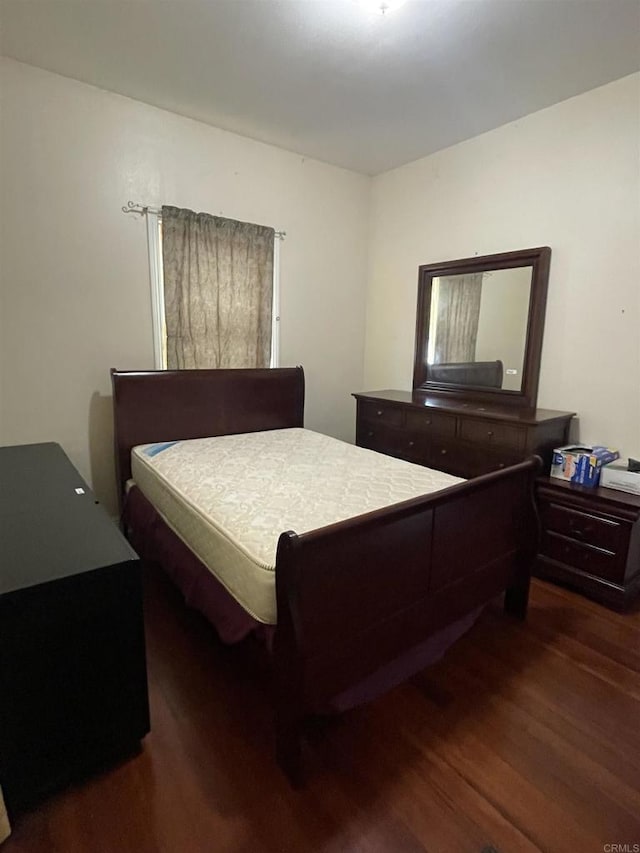 bedroom with dark wood-type flooring