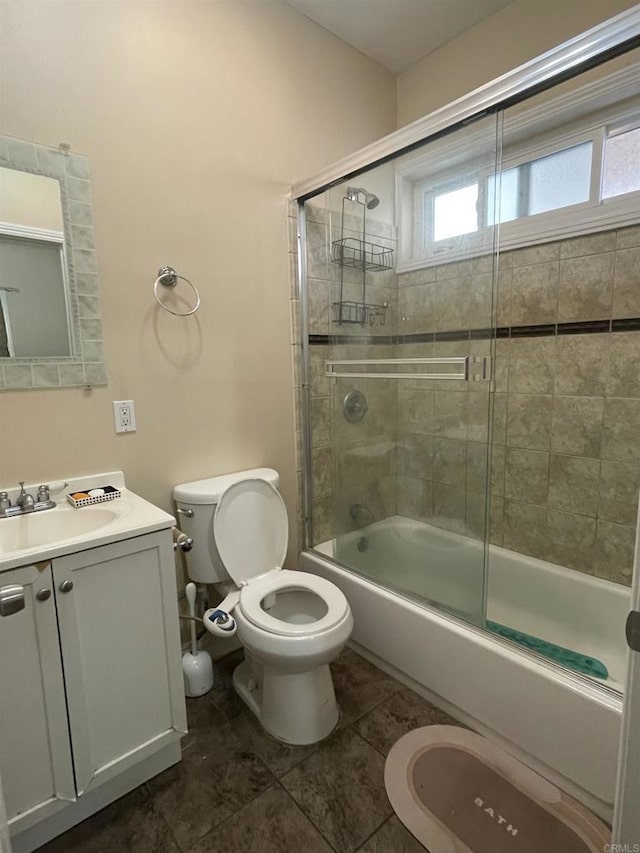 full bathroom featuring tile patterned flooring, vanity, toilet, and bath / shower combo with glass door