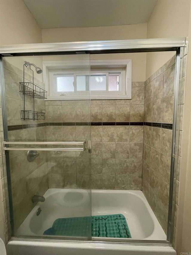 bathroom with shower / bath combination with glass door