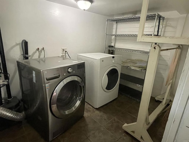 laundry room featuring washer and dryer and dark tile patterned flooring