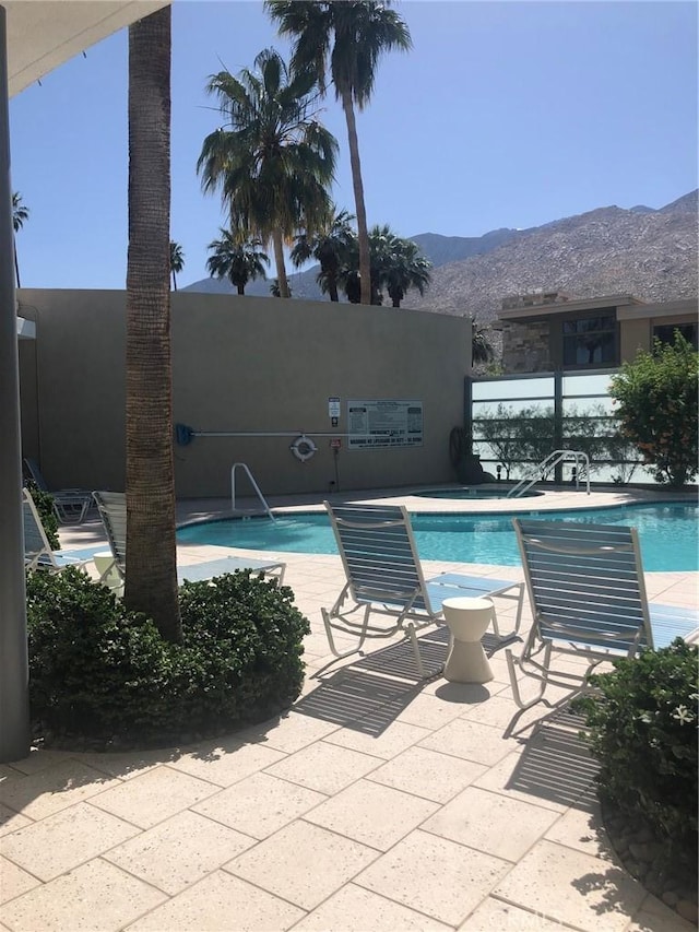 view of swimming pool featuring a mountain view and a patio area