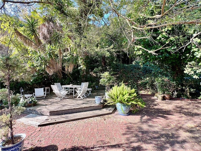 view of yard featuring outdoor dining area and a wooden deck