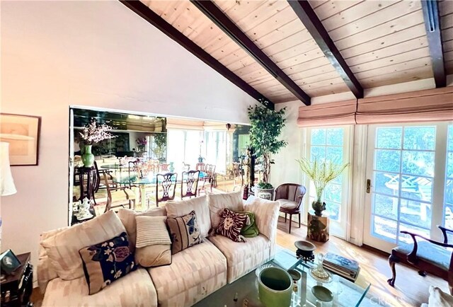 living room featuring vaulted ceiling with beams, light hardwood / wood-style flooring, and wooden ceiling