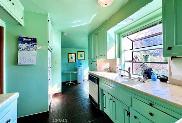 kitchen featuring a sink, tile counters, green cabinets, and dishwasher