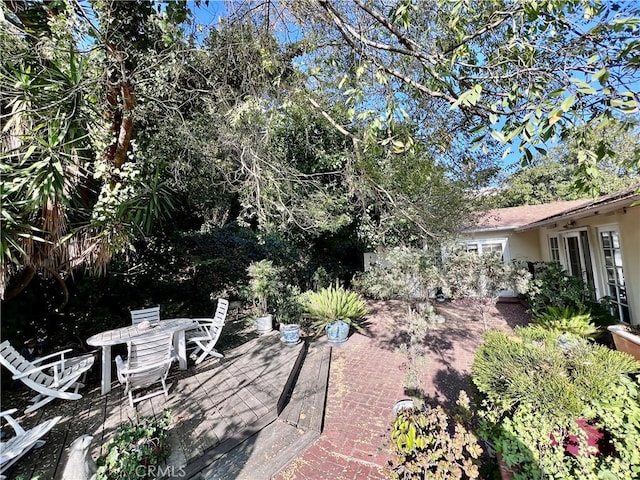 view of yard with outdoor dining space and a wooden deck