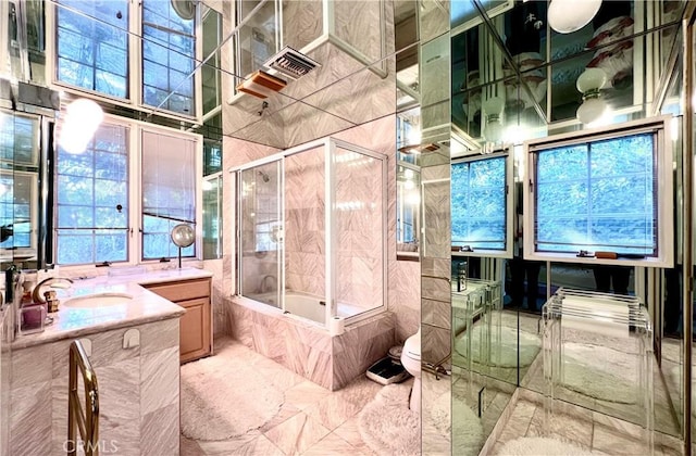 full bathroom with toilet, tiled shower / bath combo, a wealth of natural light, and vanity