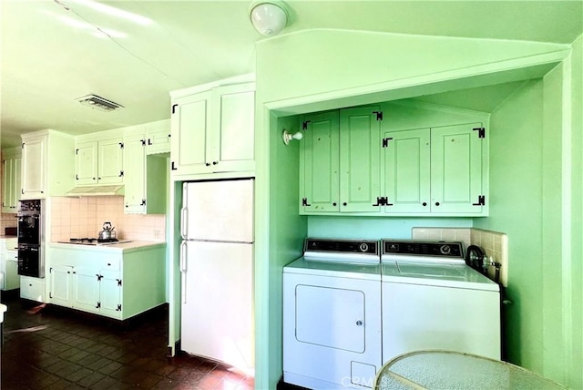 laundry room featuring visible vents, washer and clothes dryer, and brick patterned floor
