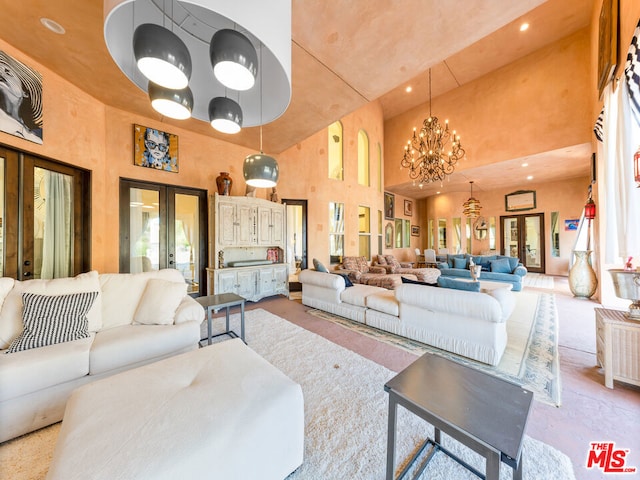 living room with a high ceiling, a notable chandelier, and french doors