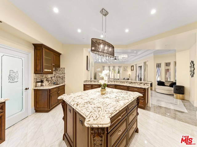 kitchen featuring a kitchen island, decorative backsplash, hanging light fixtures, ornamental molding, and kitchen peninsula