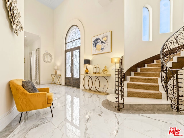 foyer entrance with a towering ceiling and french doors