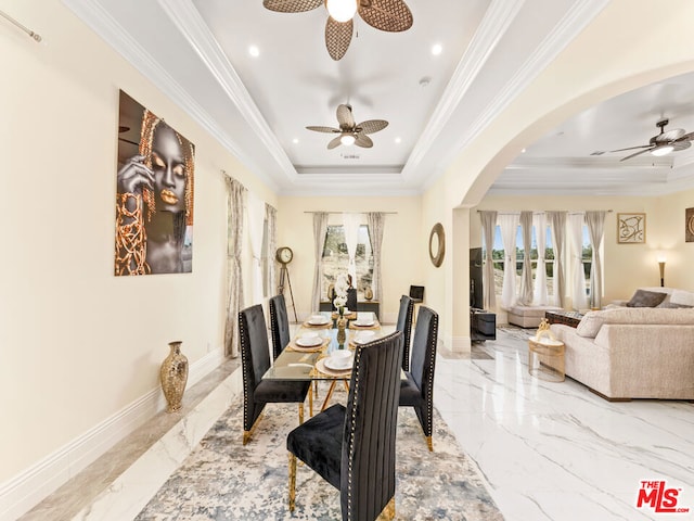 dining area with ceiling fan, crown molding, and a tray ceiling