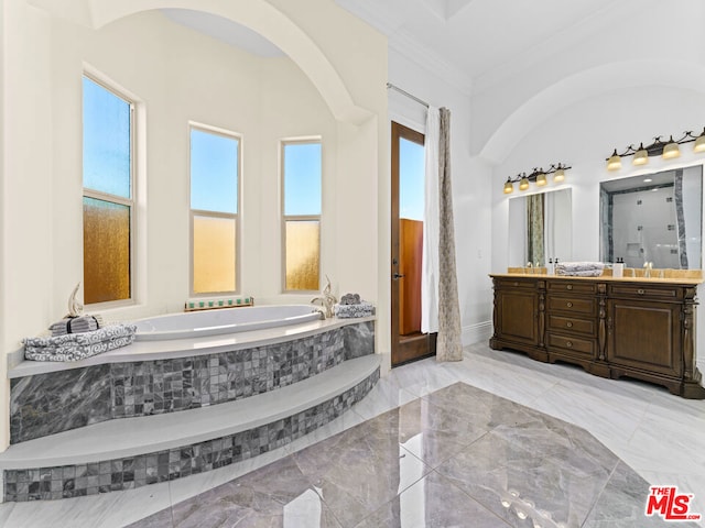 bathroom with tiled bath, plenty of natural light, vanity, and crown molding