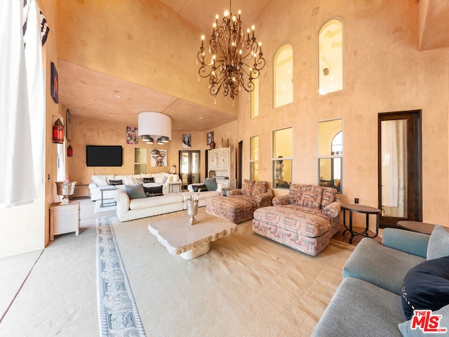 living room with a notable chandelier, a towering ceiling, and carpet flooring