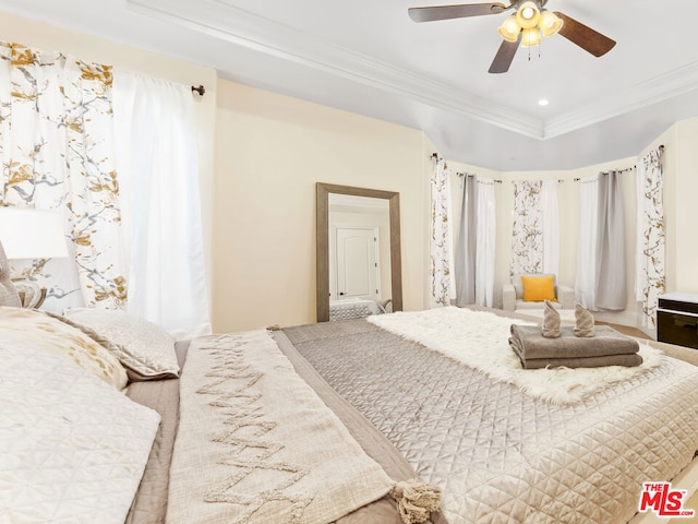 bedroom with ceiling fan, ornamental molding, and a raised ceiling