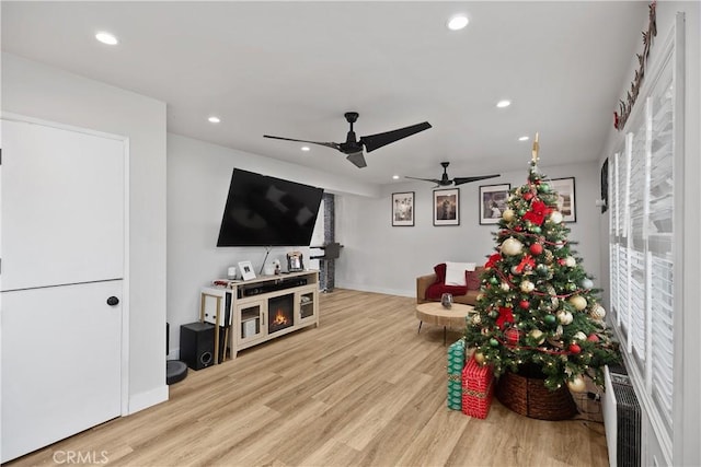 living room with hardwood / wood-style floors, ceiling fan, and radiator