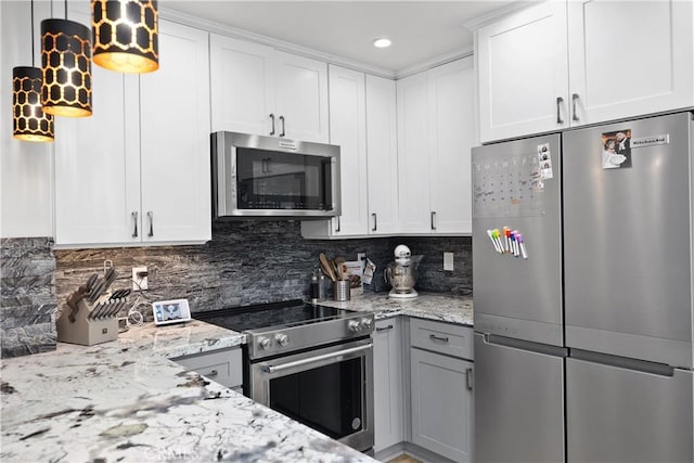 kitchen featuring light stone countertops, decorative backsplash, white cabinets, and stainless steel appliances