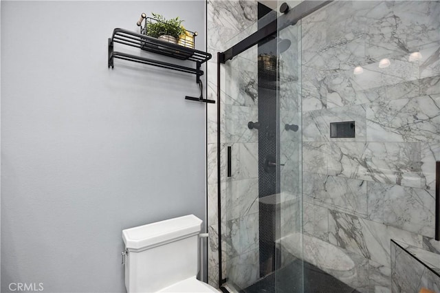 bathroom featuring toilet and a shower with shower door