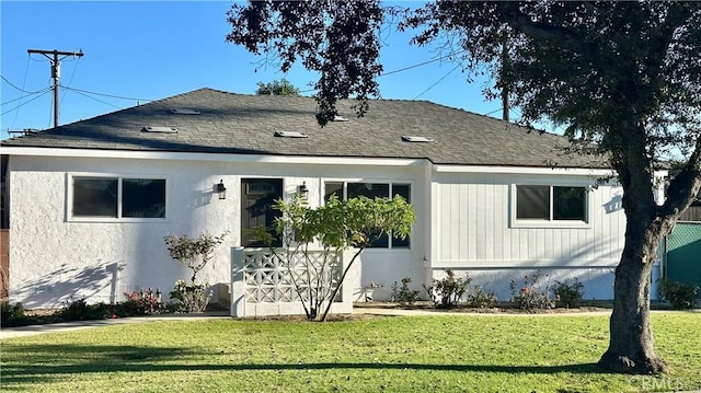 view of front of home with a front lawn and roof with shingles