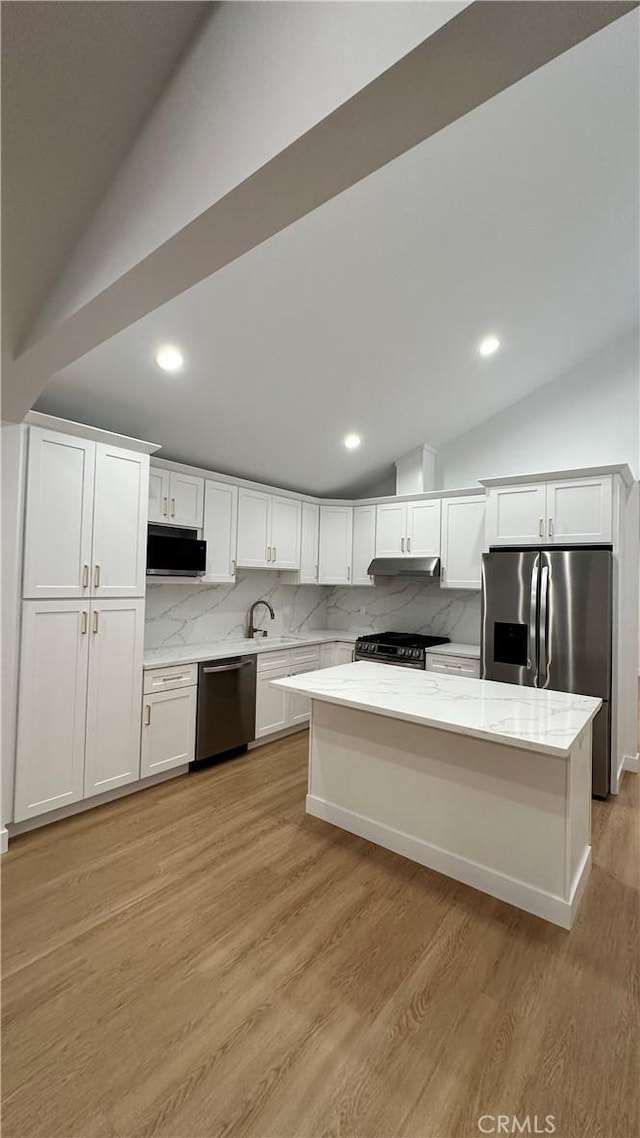 kitchen featuring white cabinets, light wood-style flooring, light stone counters, and stainless steel appliances