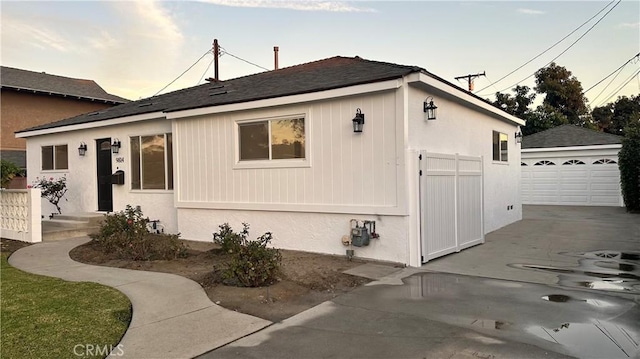 view of property exterior featuring a garage and an outbuilding