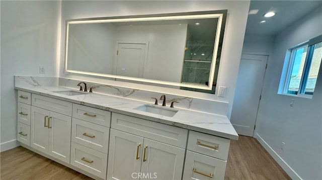 full bath with wood finished floors, a sink, and baseboards