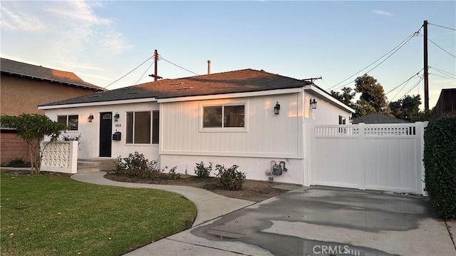 view of front of house featuring a gate, fence, and a front lawn