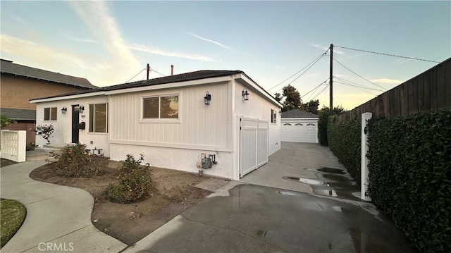 view of front of property featuring an outbuilding, fence, and a garage