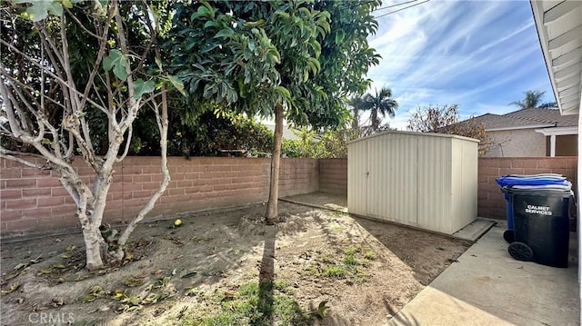 view of yard with a storage unit, an outdoor structure, and a fenced backyard