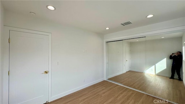 unfurnished bedroom featuring light wood-style flooring, visible vents, baseboards, and recessed lighting