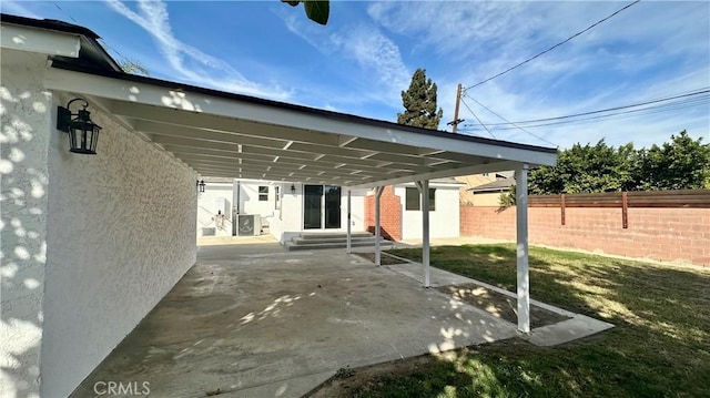 view of patio featuring a carport, entry steps, and fence