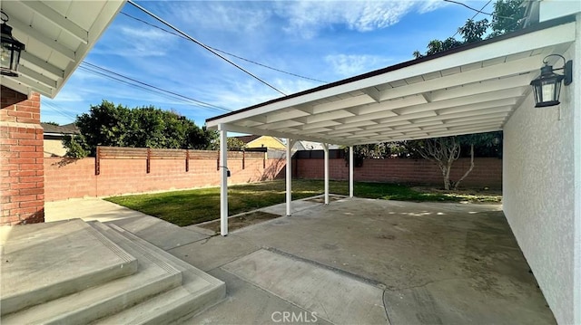 view of patio with a fenced backyard and a carport