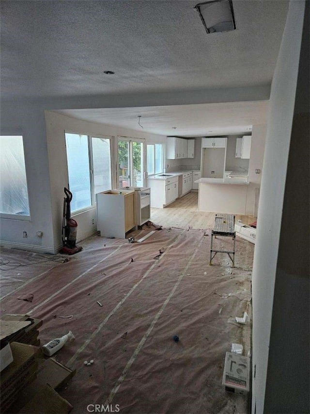 unfurnished living room with a textured ceiling and sink