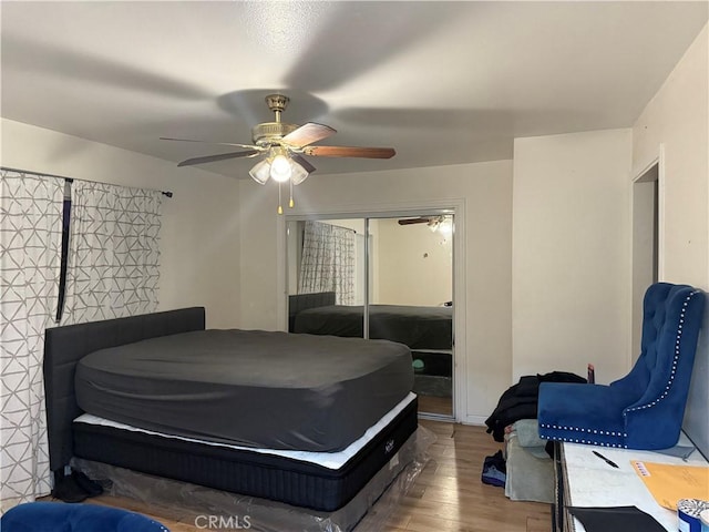 bedroom with hardwood / wood-style floors, a closet, and ceiling fan