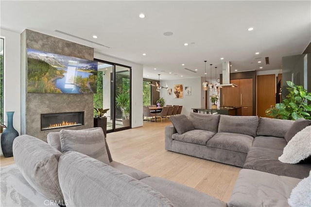 living room with light wood-type flooring and a fireplace