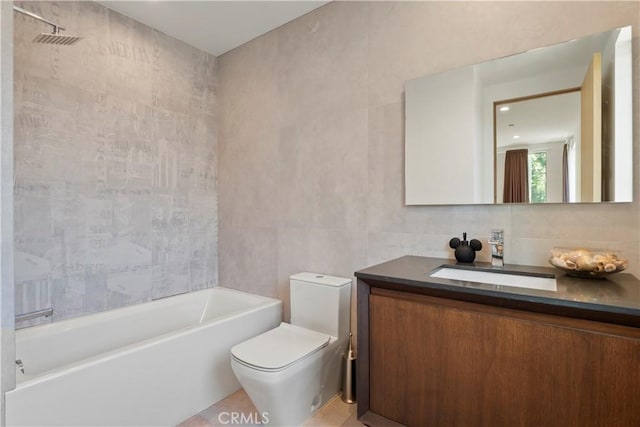 bathroom with a bathtub, vanity, tile walls, and toilet