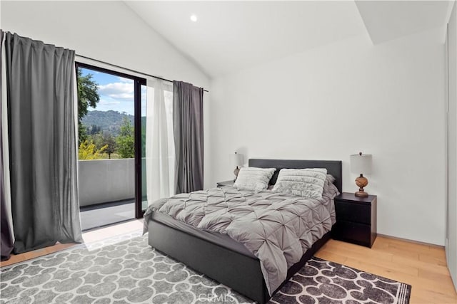 bedroom featuring access to outside, lofted ceiling, and hardwood / wood-style flooring