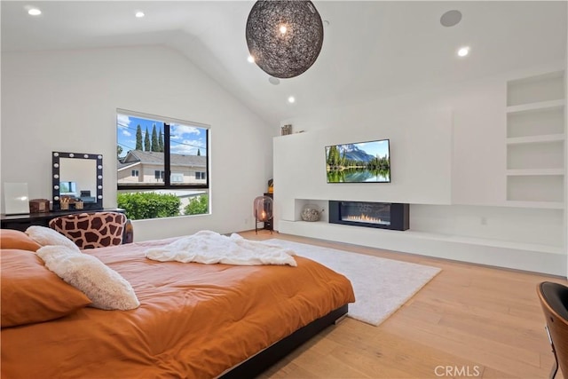 bedroom featuring wood-type flooring and high vaulted ceiling