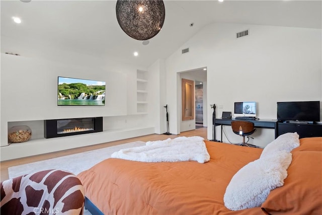 bedroom featuring high vaulted ceiling and light hardwood / wood-style flooring