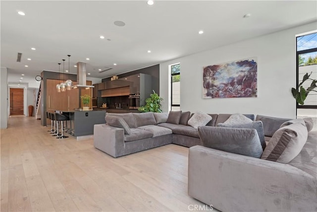 living room with a notable chandelier and light wood-type flooring