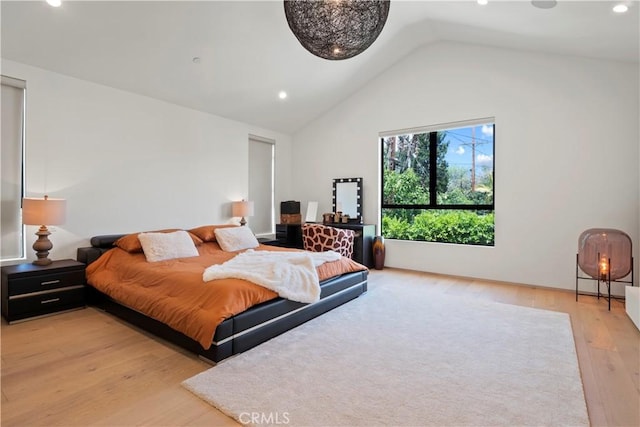 bedroom with light wood-type flooring and lofted ceiling