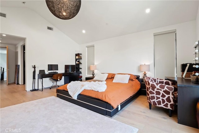 bedroom featuring high vaulted ceiling and light hardwood / wood-style flooring