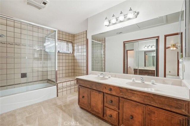 bathroom featuring ceiling fan, vanity, and combined bath / shower with glass door