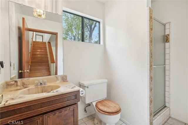 bathroom with tile patterned flooring, vanity, toilet, and an enclosed shower