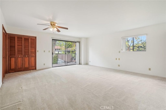 interior space with ceiling fan, light carpet, and access to outside