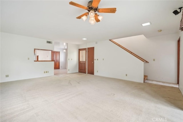 unfurnished living room featuring ceiling fan and light carpet