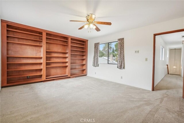 unfurnished living room with light carpet and ceiling fan